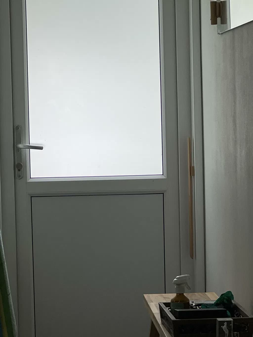 Skohorn i naturlig bøk på gråbeige vegg ved siden av hvit hagedør med matt glass